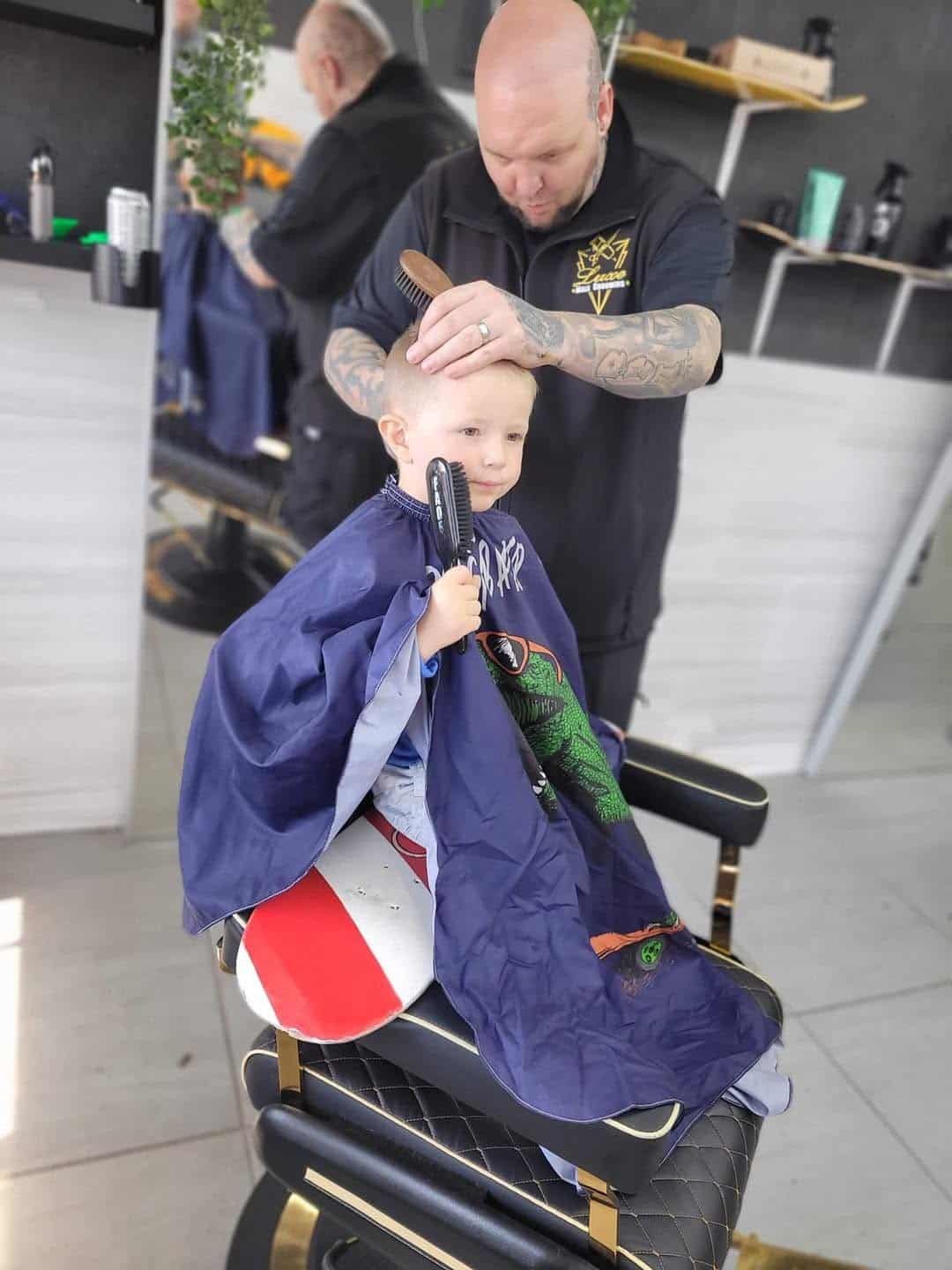 Jay cutting a child’s hair at Luxe Male Grooming
