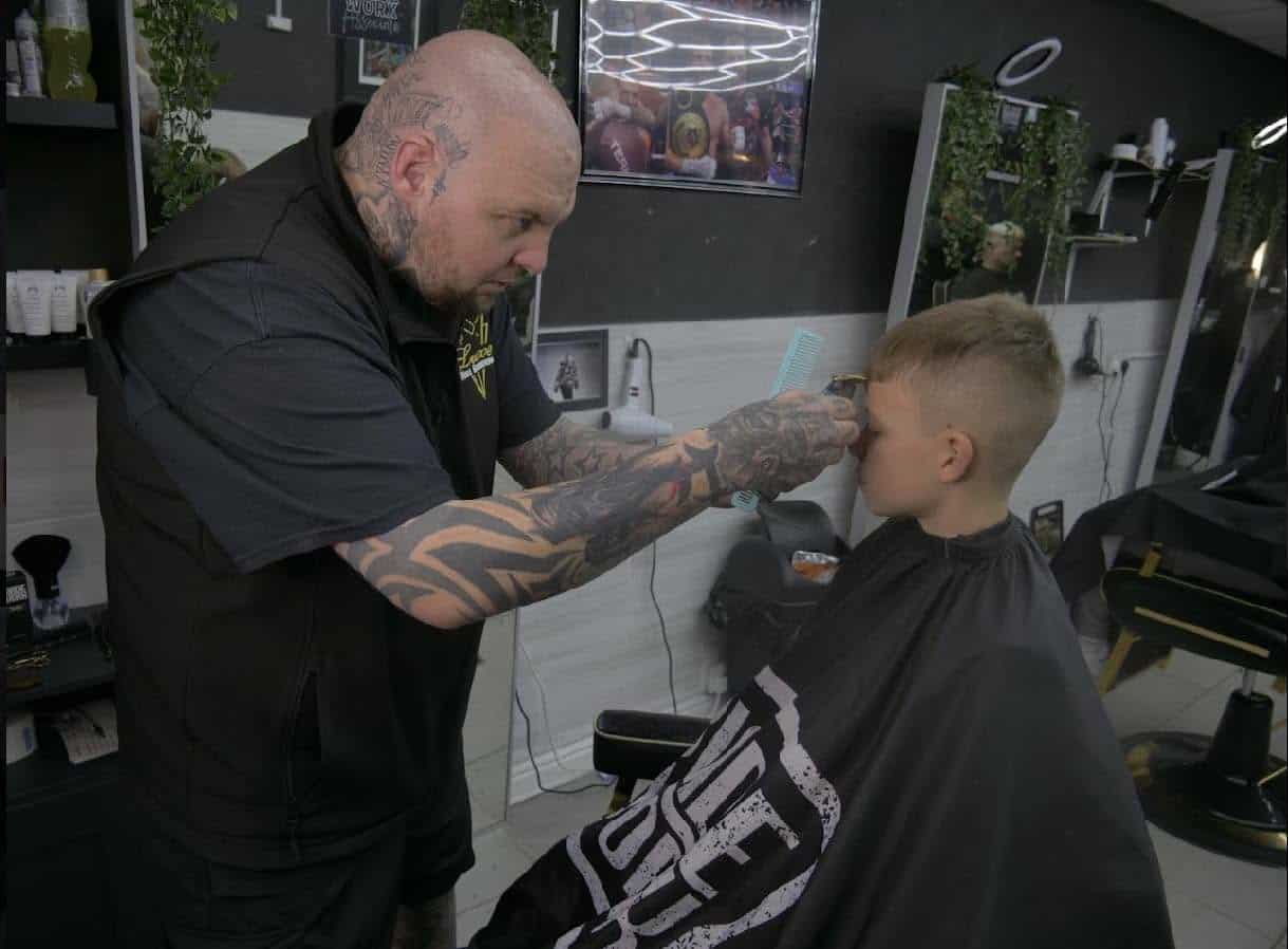 Barber shaping a boy’s haircut