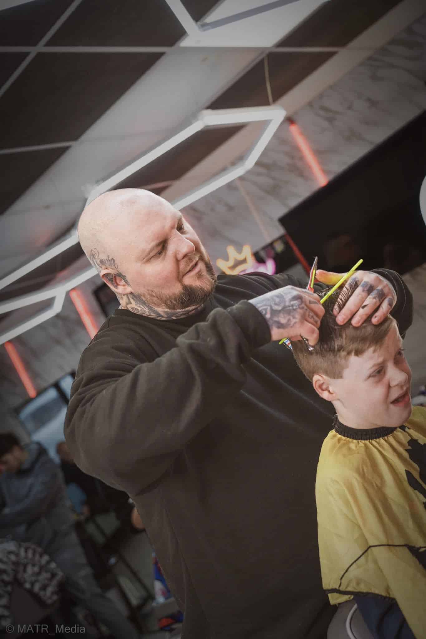 Barber giving a boy a sensory-friendly haircut